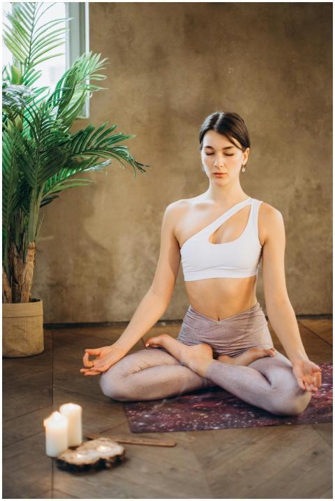 Calm woman practicing yoga in lotus pose with cand