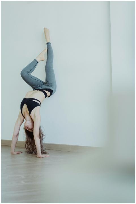 A woman in a sports bra and leggings performs a ha