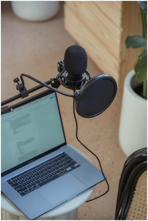 A modern podcast setup featuring a laptop and stud