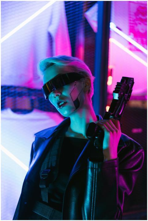 A futuristic woman in cyberpunk fashion holds a hi