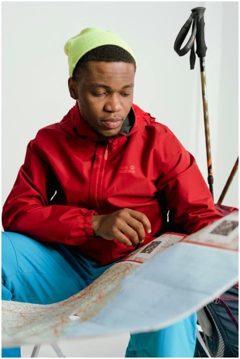 Young man in winter clothing planning a hike with