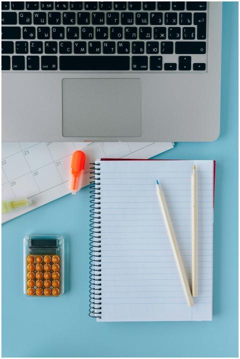 Image of a neat workspace with a laptop, calendar,