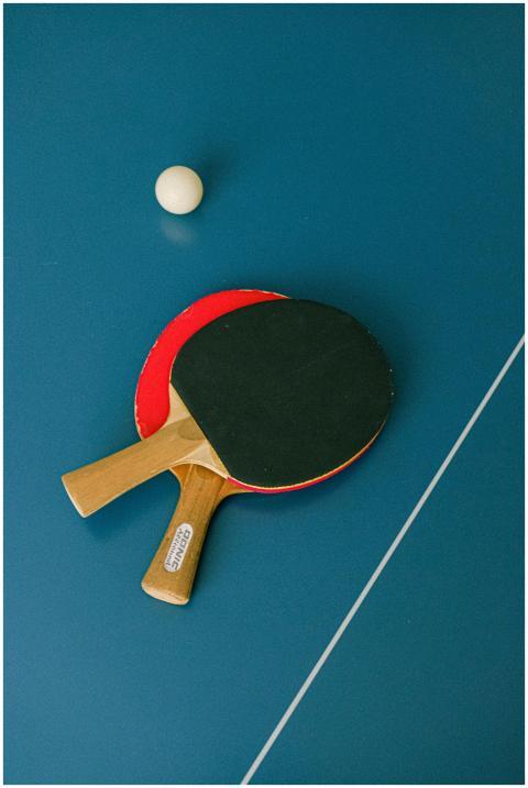 Flat lay of ping pong paddles and ball on a table