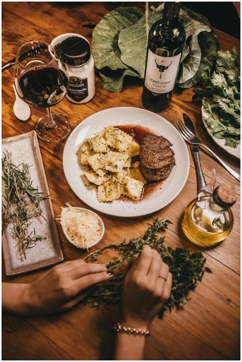 Delicious steak with ravioli and wine in a rustic