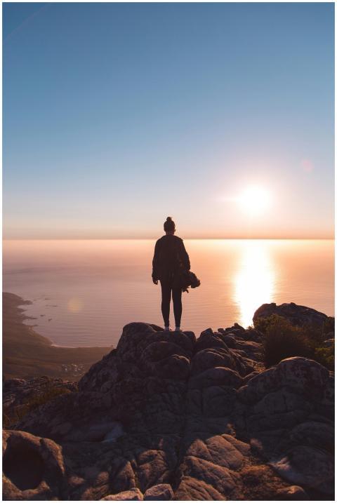 Silhouette of a person standing on a rocky cliff,
