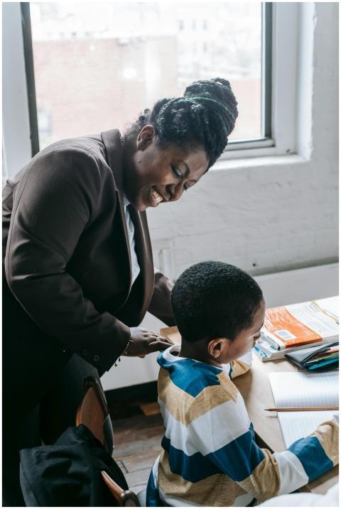High angle of smiling adult ethnic female tutor te