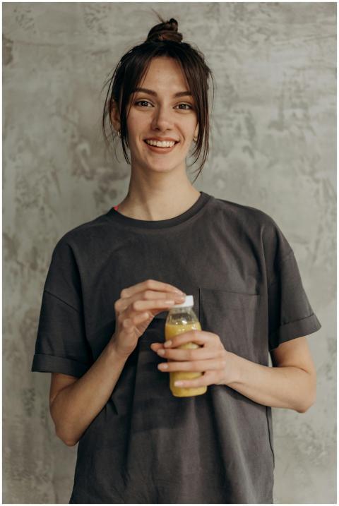 Casually dressed woman smiling and holding a juice