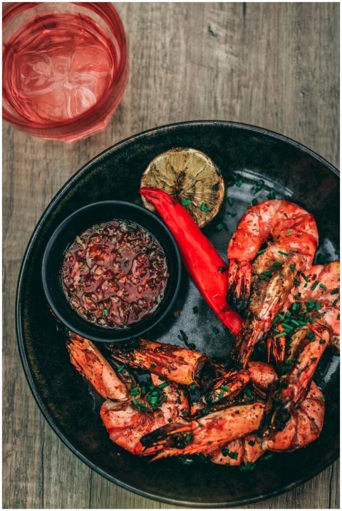 Close-up of spicy grilled shrimp with dipping sauc
