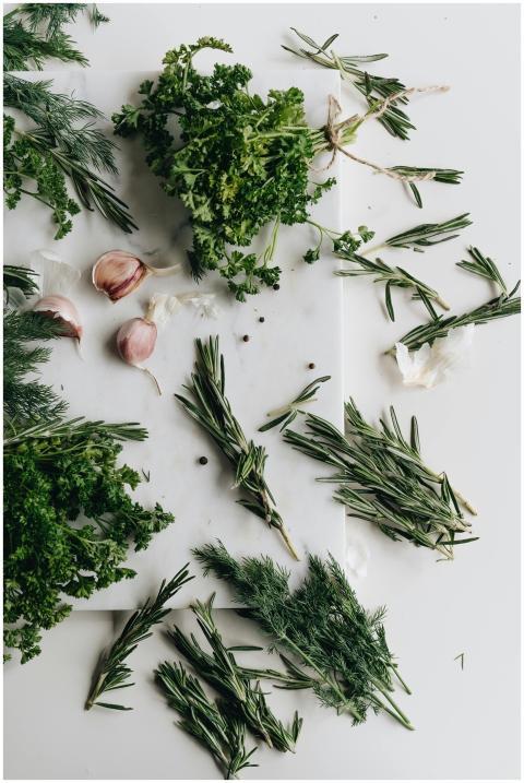 A variety of fresh herbs including garlic, parsley