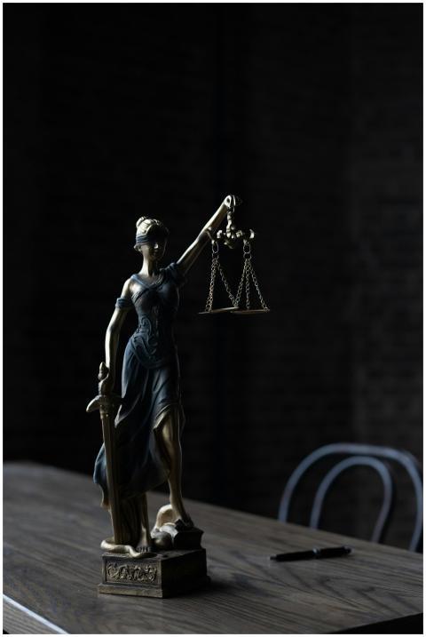 Dramatic lighting on Lady Justice figurine, symbol