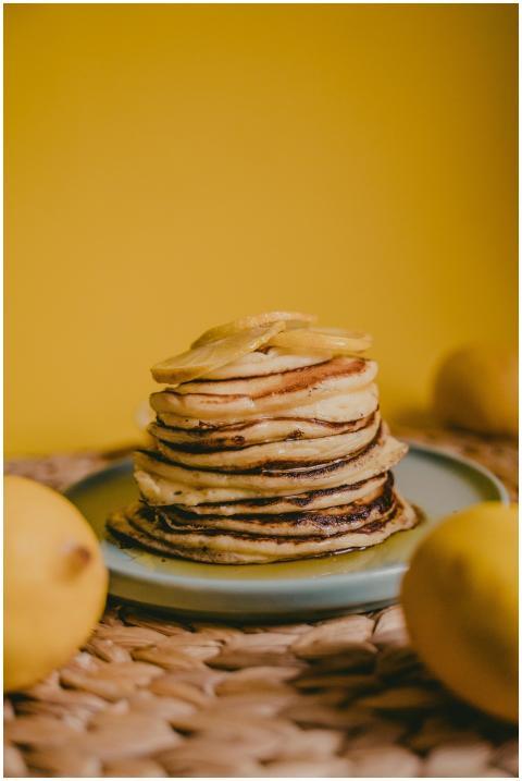 A stack of homemade pancakes garnished with lemons