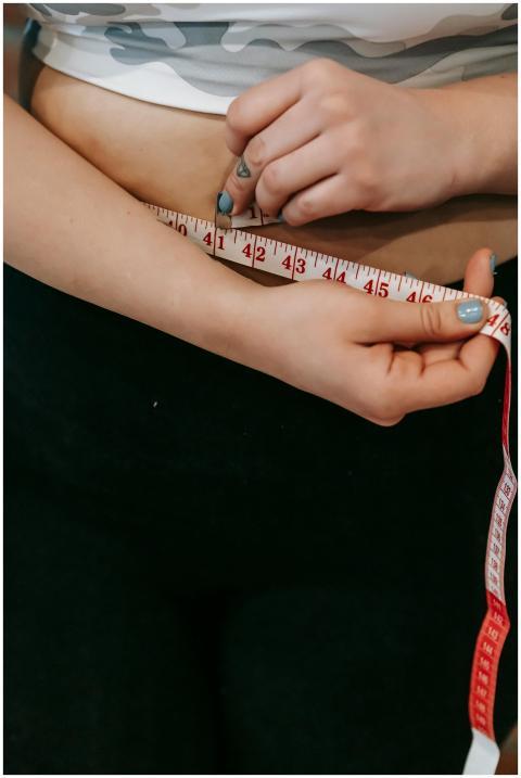 High angle of crop faceless overweight female meas