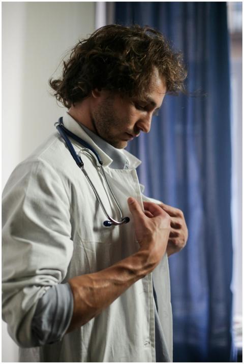 Side view of a male doctor adjusting his stethosco