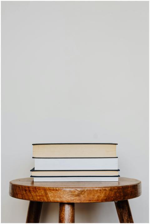 Close-up of three hardcover books stacked on a woo