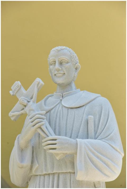 A marble statue of a religious figure holding a cr