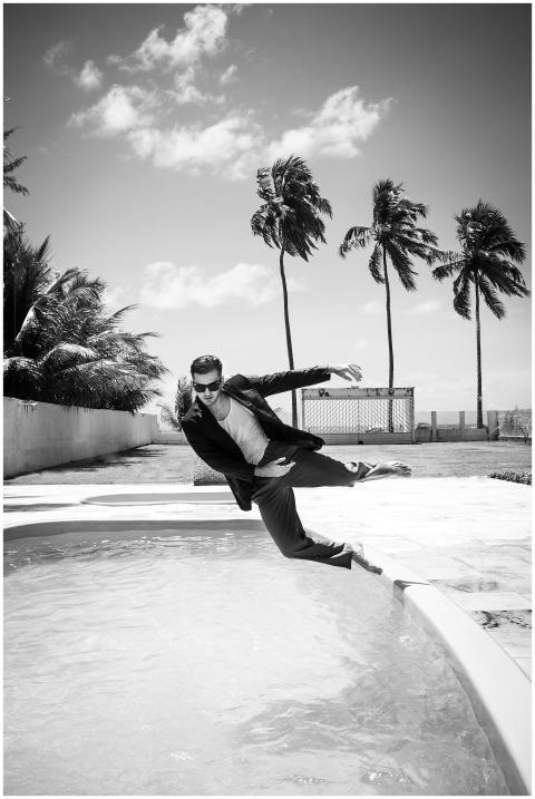 Black and white image of a man in a suit playfully