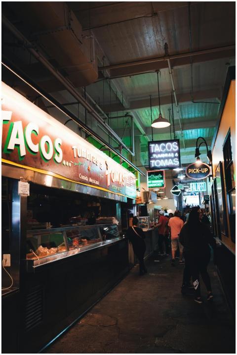 Indoor market scene with taco stalls and neon ligh
