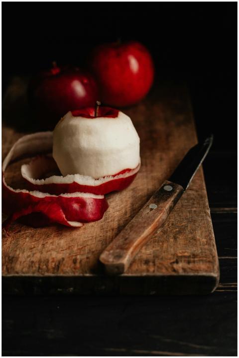 Artistic still life of a peeled apple with red ski