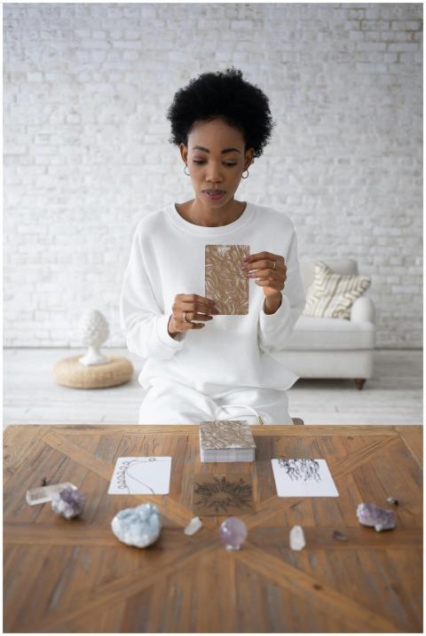 African American woman holding tarot cards with cr