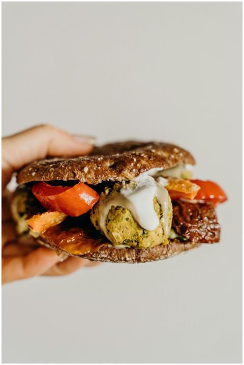 Hand holding a delicious falafel sandwich with vib