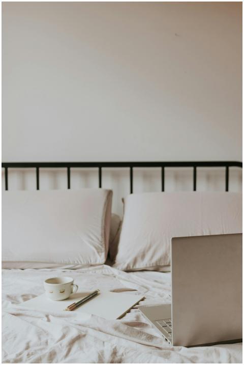 A minimalist home office setup on a bed with lapto