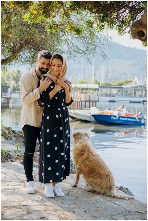 Gentle embrace by a scenic lakeside with a loyal d