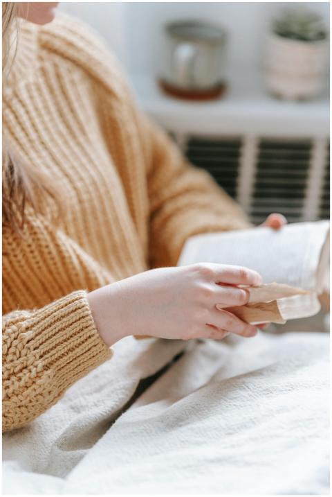 A woman reading a book in a cozy setting, wrapped