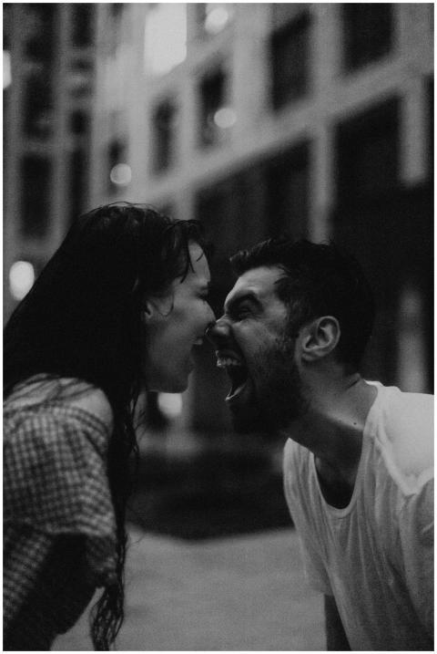 Black and white image of a couple arguing on a cit