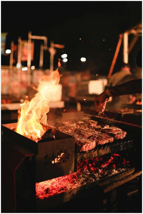 Vibrant night scene of a BBQ grill with sizzling m