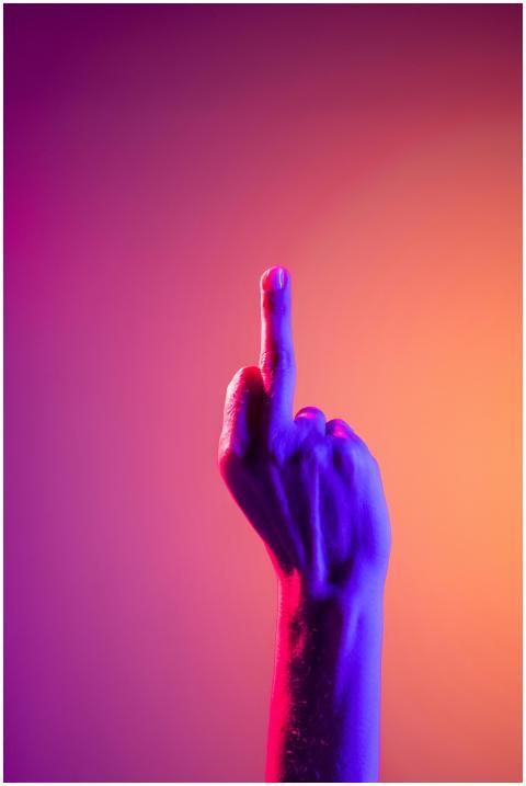 A vibrant neon-lit hand gesture showing the middle