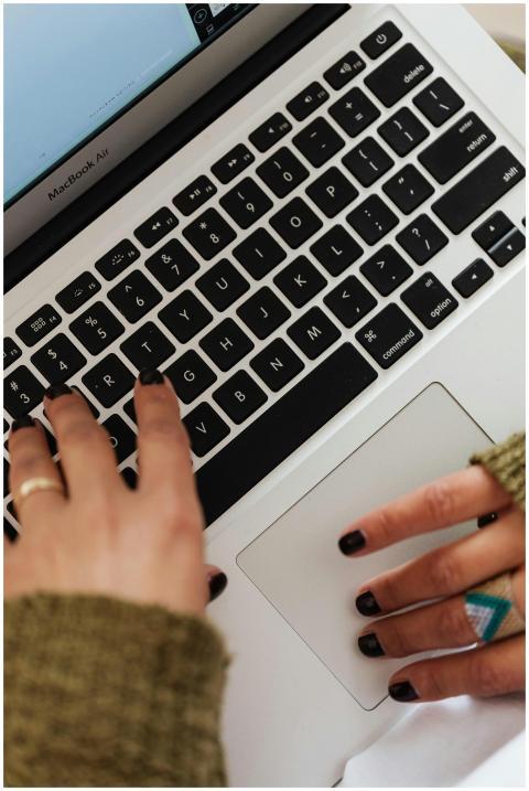 Close-up of hands typing on a MacBook Air keyboard