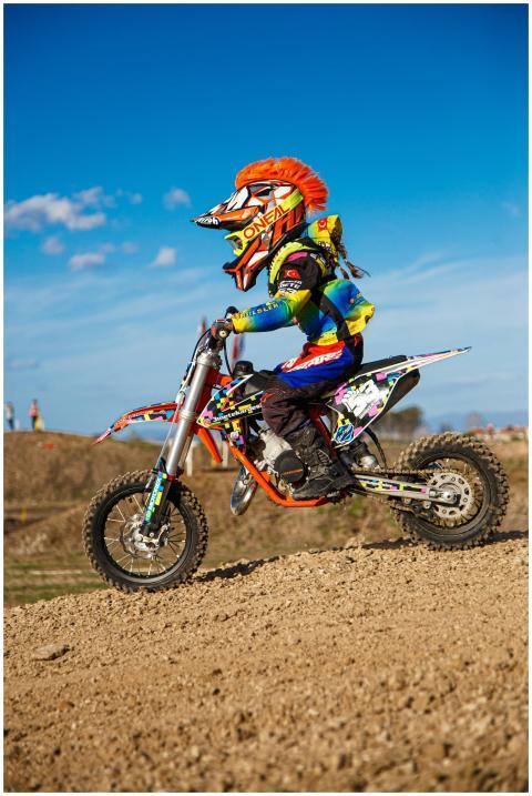 Young racer on a dirt bike with helmet and gear, s