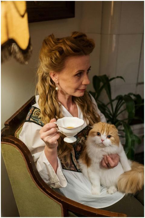 Elegant woman drinks tea indoors while holding a S