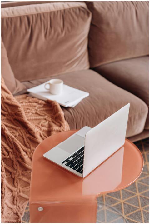A modern laptop on a stylish table with warm decor