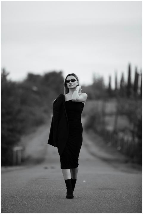 Elegant woman in a black dress posing stylishly on