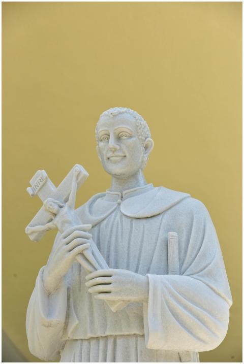 White marble statue of saint holding a crucifix, o
