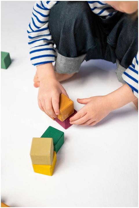 Young child playing creatively with colorful woode