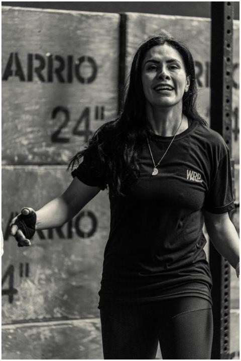 Smiling woman exercising in gym, black and white f