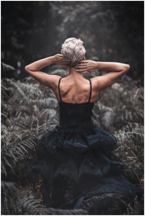 Rear view of a woman in a black dress surrounded b