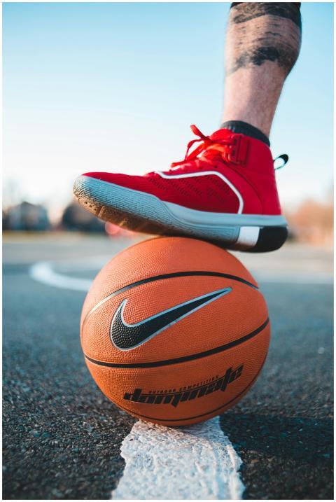 Close-up of a foot in red sneaker balancing on a b