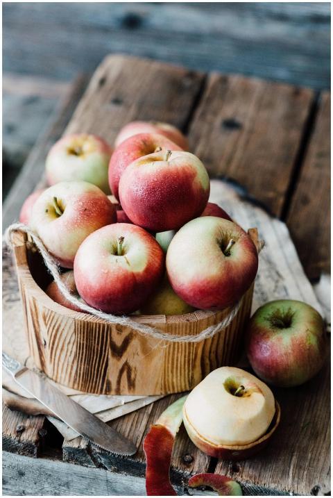A close-up of ripe apples in a wooden basket on ru
