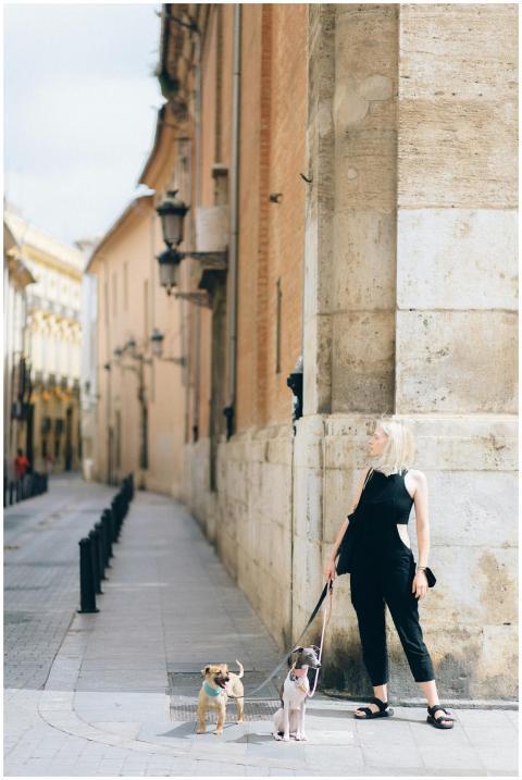 Blonde woman with two dogs on leash walking along