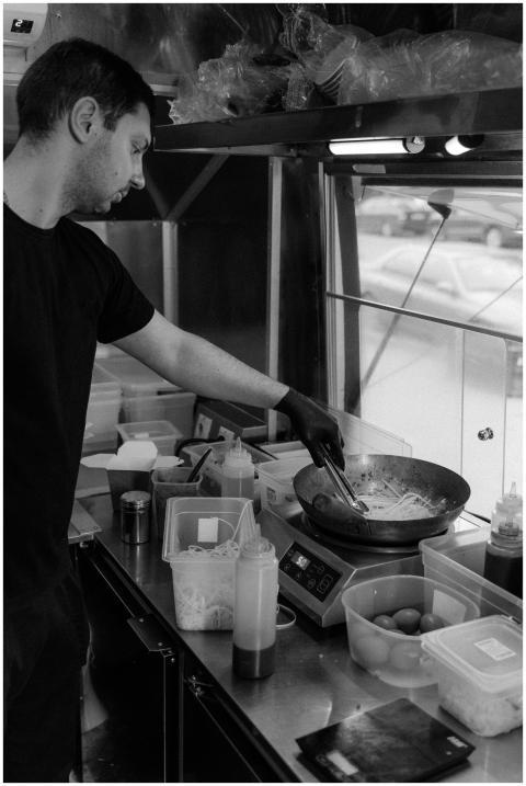 Black and white photo of a chef cooking in a food