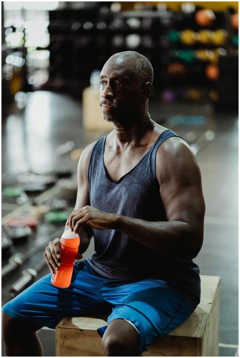 Fit African American man taking a break, holding a