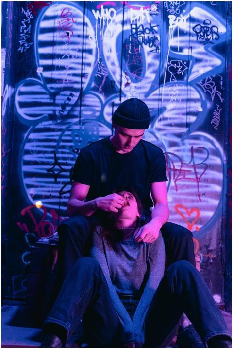Couple sitting in urban setting with graffiti wall