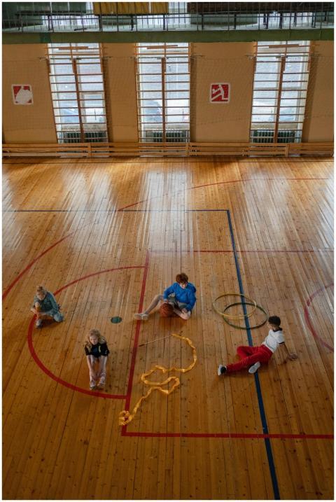 Kids are engaging in activities on a wooden sports