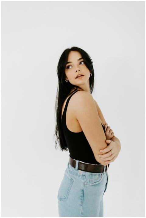 Stylish woman posing in casual attire against a wh