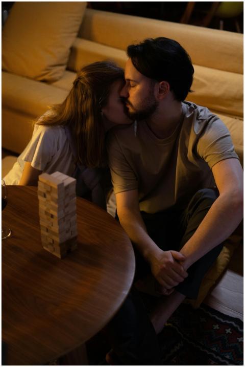 A couple embracing while playing a board game at h