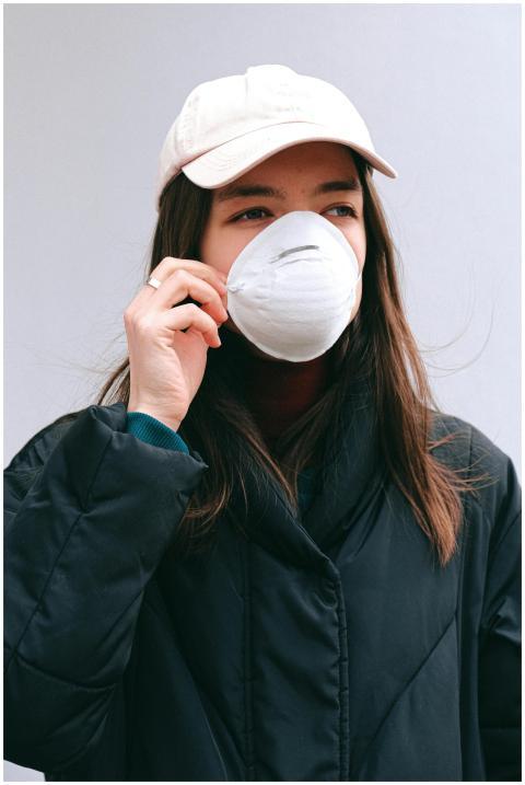 Portrait of a young woman outdoors wearing a face