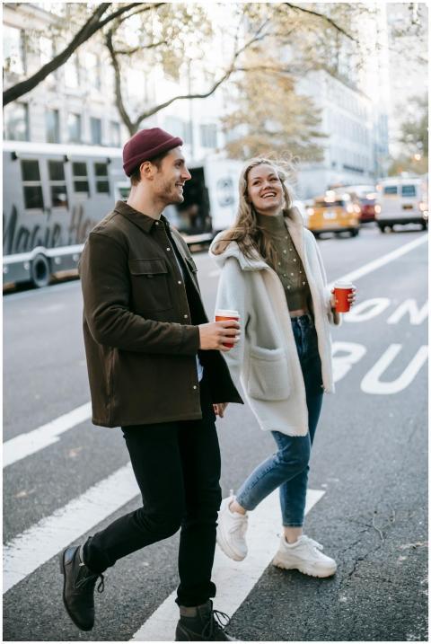 Young smiling couple in warm clothes strolling on